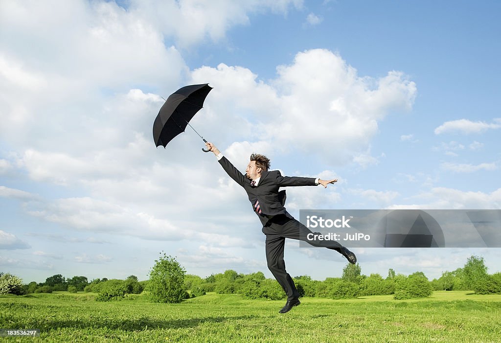 Fly Businessman with an umbrella Activity Stock Photo