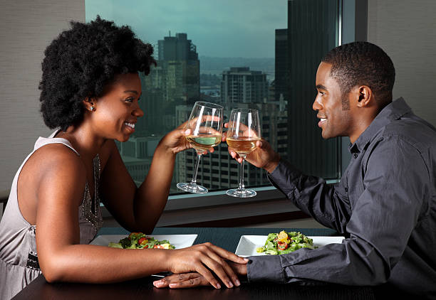 African American Couple on a Dinner Date This is a photo of a young African American couple having a romantic dinner together. There are similar images of this couple in the lightbox below. formal dinning stock pictures, royalty-free photos & images