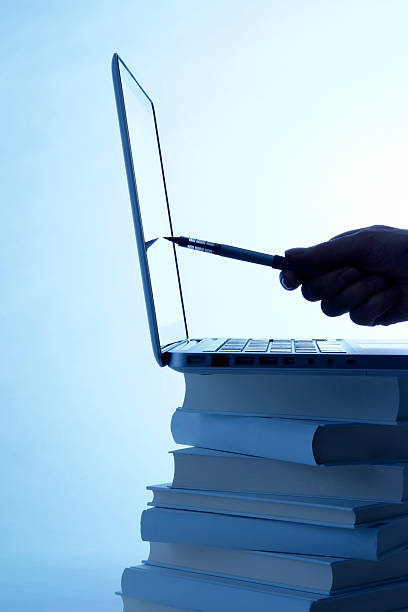 istock Blue tinted image of laptop and holding a pen 183537597