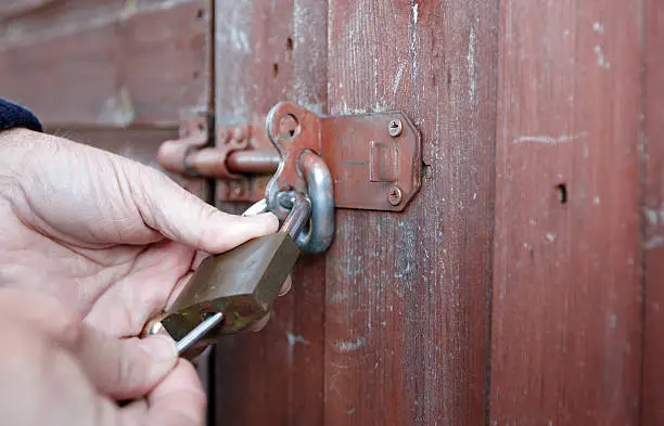 Photo of Man's hands unlocking padlock