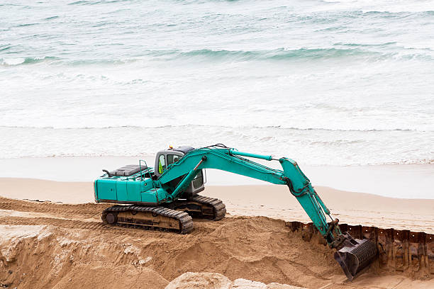 istock Excavator diigin sand on the beach 183539013