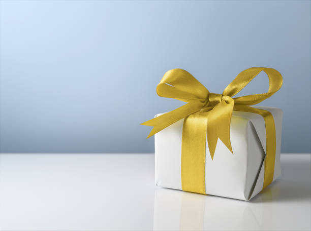 istock White gift box with gold satin bow on grey background 1835403815