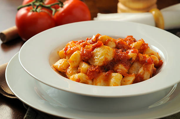 Gnocchi in a white bowl with tomato sauce stock photo