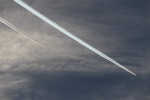 Airplane trails in the cloudy sky, 2 contails