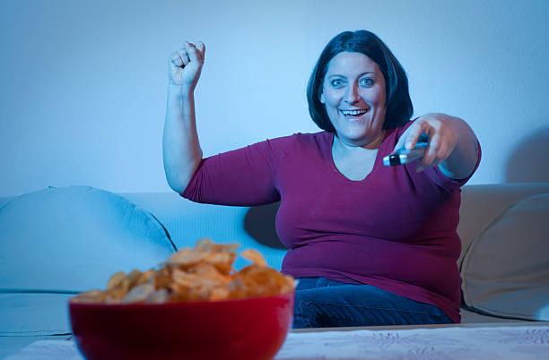 istock Overweight woman watching TV 183541245