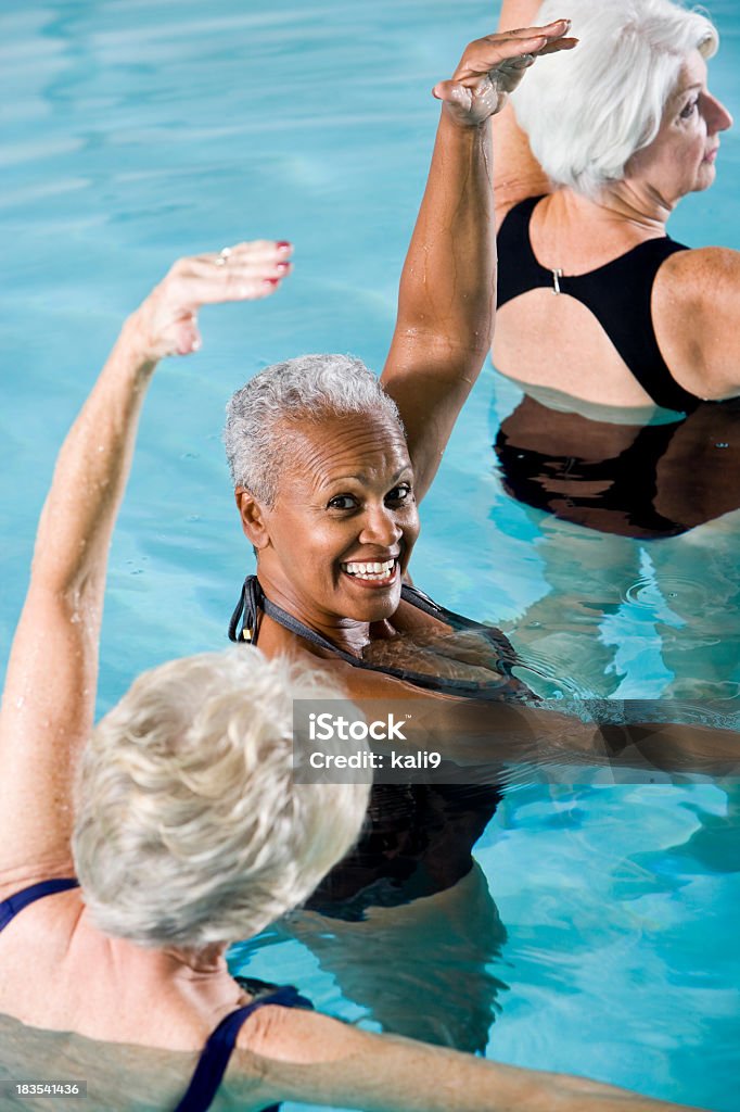 Multirazziale senior donne in classe di Aerobica acquatica - Foto stock royalty-free di Aerobica acquatica
