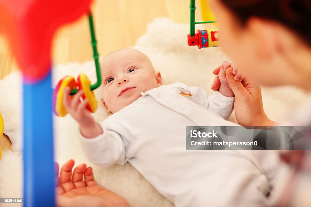 Baby using fine motor skills to play Baby playing and learning motor skills. Baby - Human Age Stock Photo