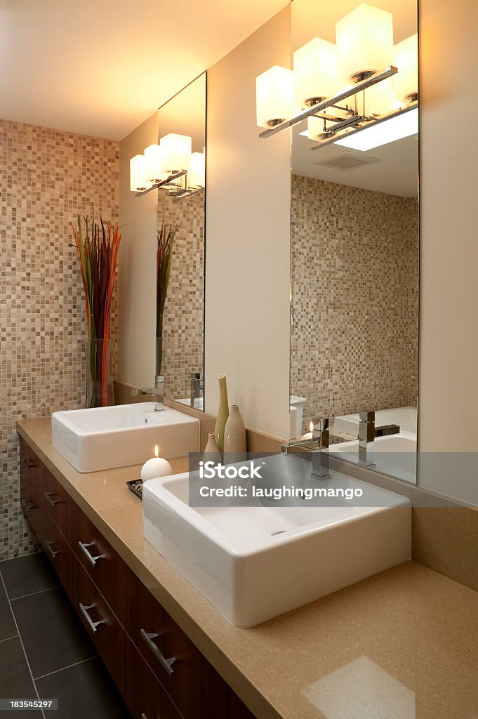 Photo of lit bathroom with modern his and hers sinks modern bathroom sink Apartment Stock Photo