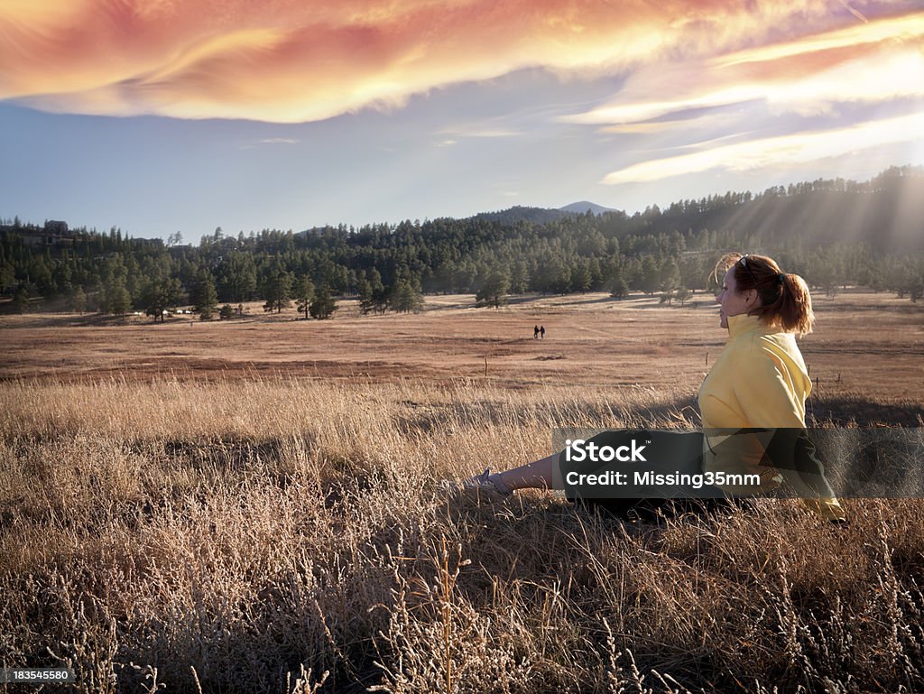 Deportiva mujer relajante en el prado con puesta de sol - Foto de stock de Adulto libre de derechos