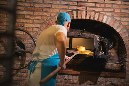 A reconstructed historic wooden cart, wooden wagon with a clay oven on top with baked bread. Baking bread in the old days.