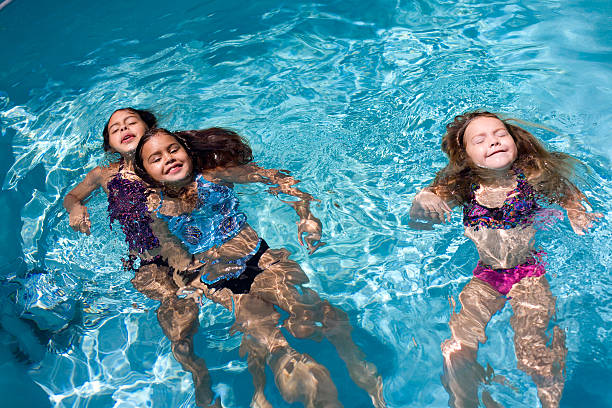 Young girls swimming backwards in the pool