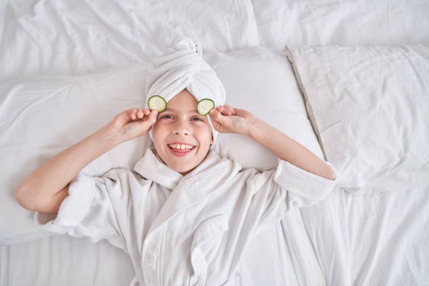 istock Boy taking off cucumber slices from eyes during spa procedures 1835477911