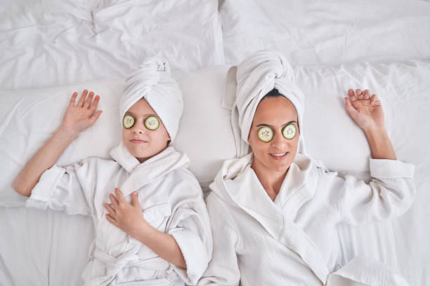 Mother wand son with cucumber slices on eyes