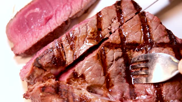 barbecue fresh beef meat with blood steak serving delicious food cut with a knife several videos of one process of cooking delicious bbq steak