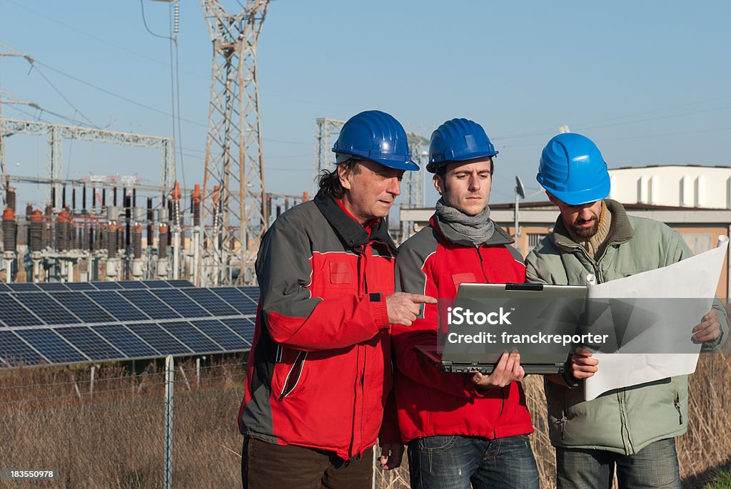 Technicians engineer and solar panels on laptop  Adult Stock Photo