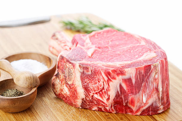 gourmet ribeye стейк - animal bone chop close up color image стоковые фото и изображения