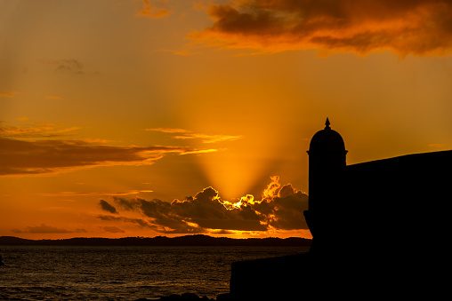 Silhouette of the tip of a nautical fort. Dramatic and orange sunset.
