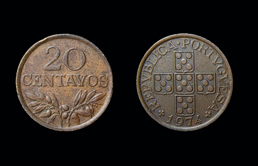 A closeup of Portugese 20 centavos coins on a black background