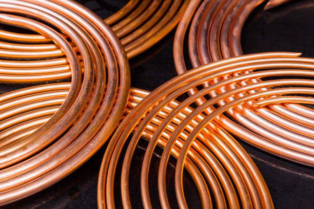 Twisted new copper tubes on a black background.