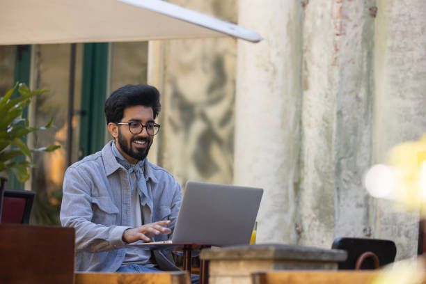 istock Dark-haired young hindu man working on laptop in a cafe 1835594978