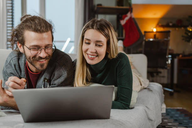 istock Beautiful couple using laptop at home during Christmastime 1835606721