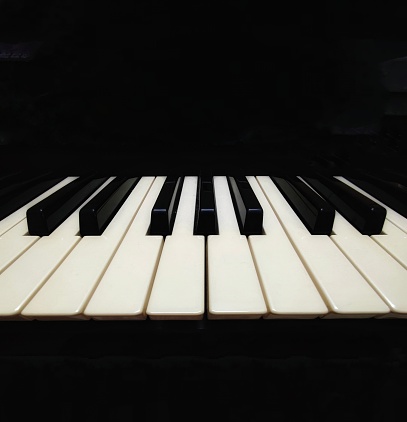 A closeup of piano keys on a black background