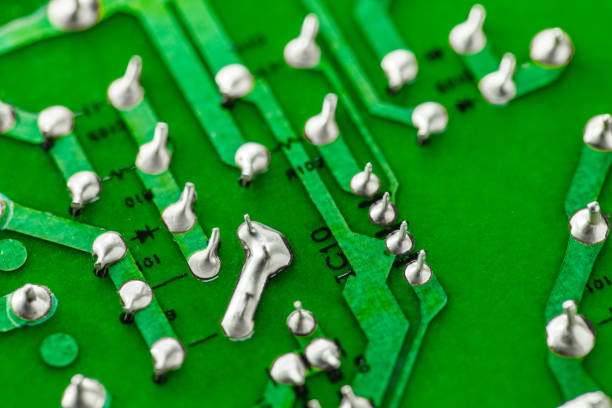 Electronic green printed circuit board with soldered copper tin contacts, close-up, selective focus