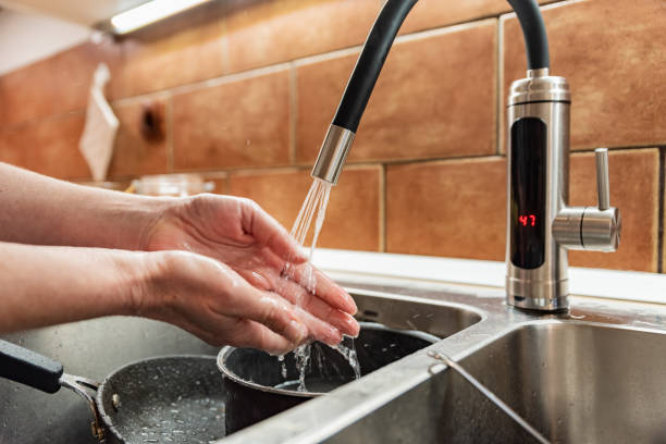 istock Woman Washing Hands in the Kitchen Sink 1835638818