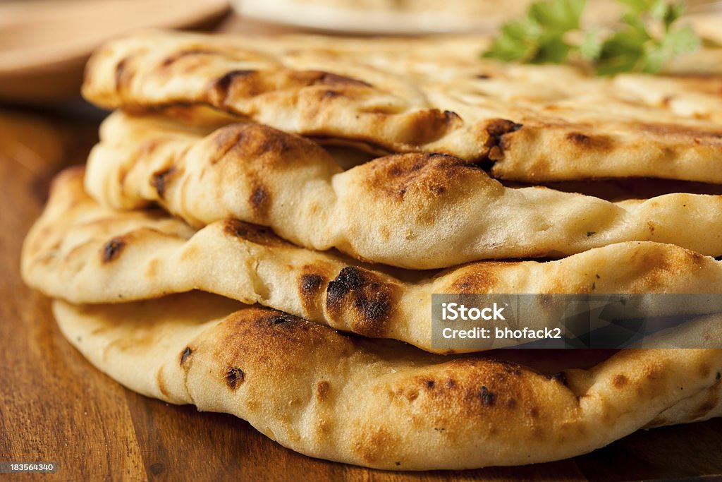 Close-up photograph of a pile of plain naan flatbreads Homemade Indian Naan Flatbread made with Whole Wheat Naan Bread Stock Photo
