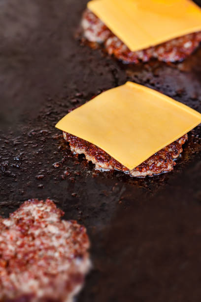 istock Beef patty chop covered with square piece of cheese fried on baking sheet, close-up, selective focus 1835645285