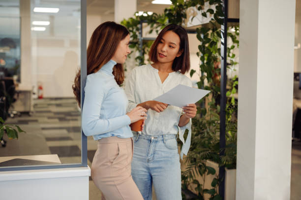 istock Diverse business women looking into some paperwork while standing in the office 1835663758