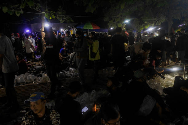 indulgence communautaire : transactions crépusculaires au marché nocturne aux poissons de jatinegara - dealings photos et images de collection