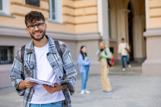istock Young guy in eyeglasses and checkered shirt in the university yard 1835669049