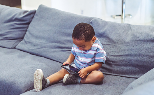 Little boy uses a cellphone at home