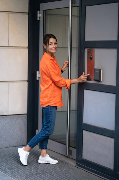 istock Brunette woman dialing an intercom to enter a building. 1835692591