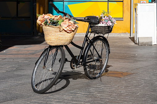 In a street in Avila-Spain, next to a small flower shop, an old disused bicycle is used as an ornament to display decorative plants.