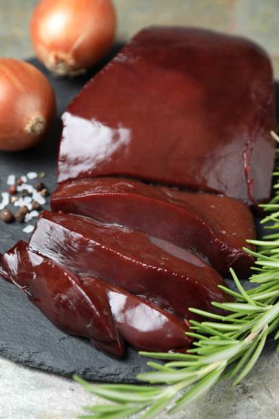 istock Cut raw beef liver with rosemary and onions on grey table, closeup 1835700096