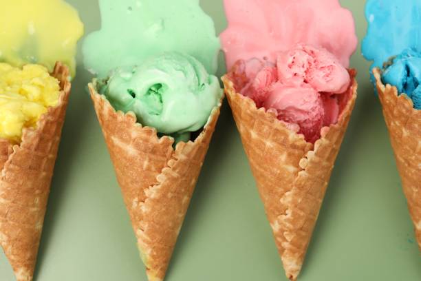 istock Melted ice cream in wafer cones on pale green background, flat lay 1835713443
