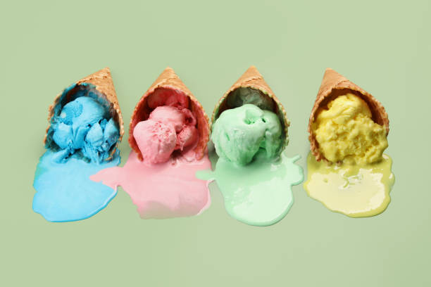 istock Melted ice cream in wafer cones on pale green background. 1835715635