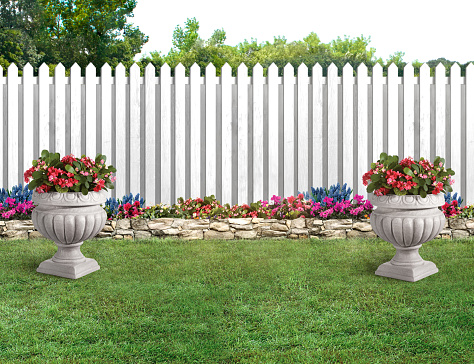 Decorative floral stands in a backyard with green grass and white picket fence