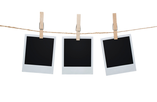 Three Polaroid pictures hanging on a clothesline with pins