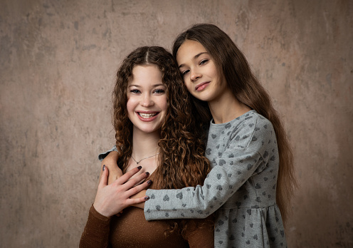 Boy and girl hugging each other on white background. Happy young kids. Portrait of brother and sister having fun. Two children's friendship.