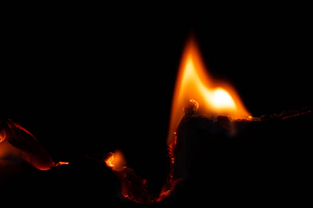 istock burning paper, glowing edge of paper on a black background 1835752037
