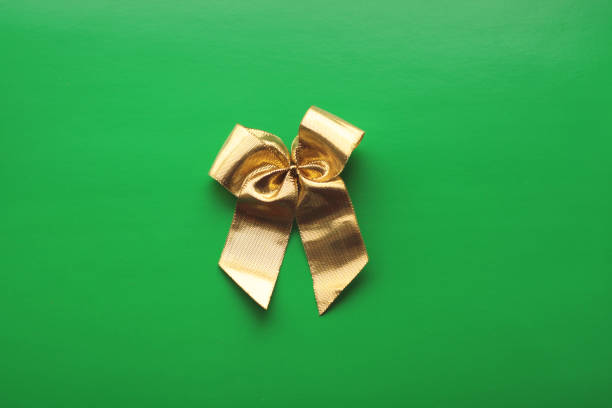 istock one golden bow on a green background 1835753121