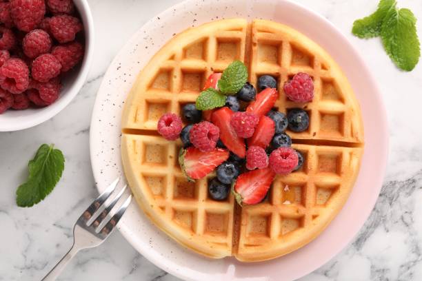 istock Tasty Belgian waffle with fresh berries served on white marble table, flat lay 1835768843