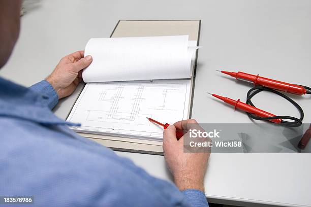 Checking The Wiring Diagram Stock Photo - Download Image Now - Desk, Electrician, Adult