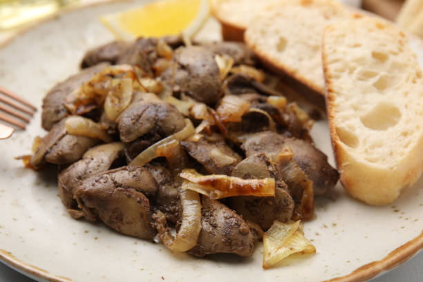 istock Tasty fried chicken liver with onion and bread on white table, closeup 1835791920
