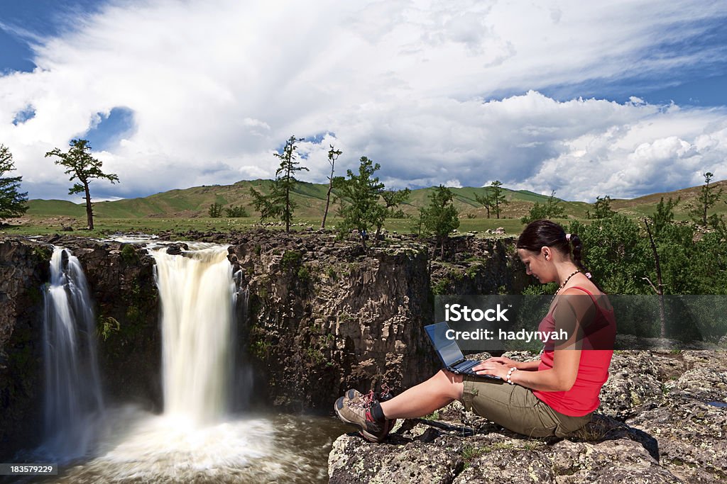 Молодая женщина с ноутбуком на скалах - Стоковые фото Гора роялти-фри