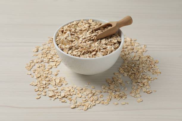 istock Bowl with oatmeal and scoop on white wooden table 1835797393