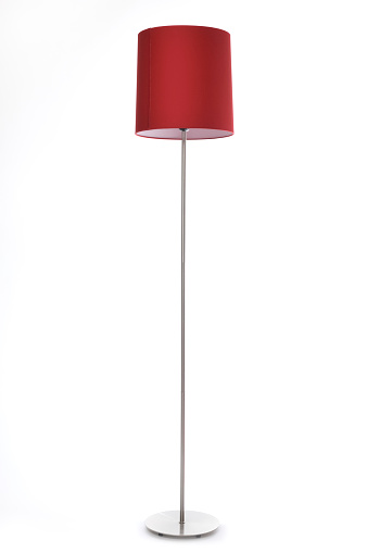 A standing red lamp with a metal base isolated on white.